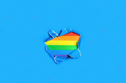 A flag with the colors of the rainbow. Underneath, torn blue paper
